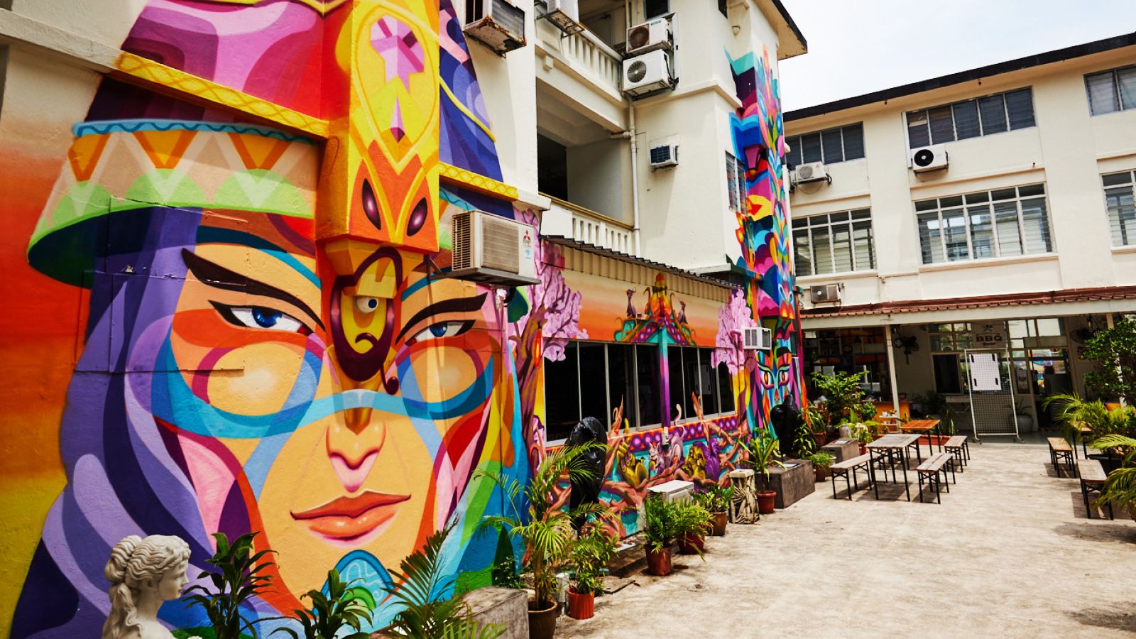 The big mural of a woman's face in the 195 Pearl's Hill Terrace courtyard